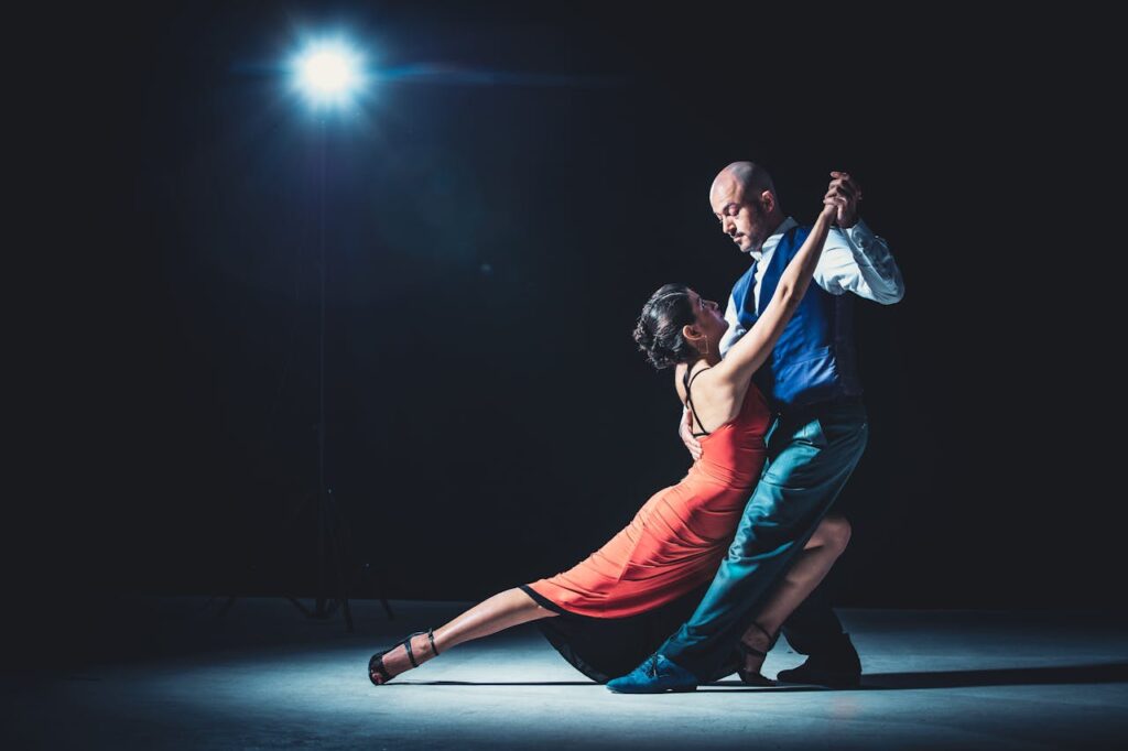 tango shows buenos aires Elegant couple performing tango under a dramatic spotlight, showcasing passion and grace.